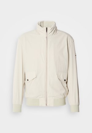 Heledbeez värvi jakk kõrge kraega, lukuga, kahe klapiga taskuga ja soonikkoes mansettidega. Valmistatud pehmest, siledast materjalist.