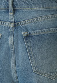 Lichtblauwe denim jeans met een klassieke vijf-pocket stijl, zichtbare stiksels en een gestructureerde stof met een licht vervaagd uiterlijk.