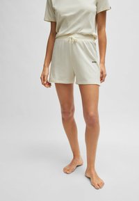 Ljusbeiga shorts i mjukt tyg, med resårmidja och dragsko. Litet "BOSS"-logotyp på vänster framsida.