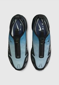 Un paio di sneakers Nike Air blu e nere con zip frontali e loghi swoosh bianchi, viste dall'alto su uno sfondo grigio.