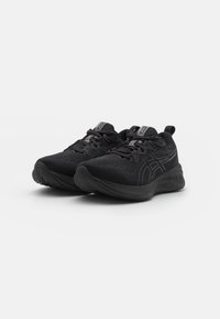 Scarpe sportive nere con tomaia in mesh, caratterizzate da una suola testurizzata e accenti riflettenti. Progettate con lacci e un collare imbottito per il comfort.