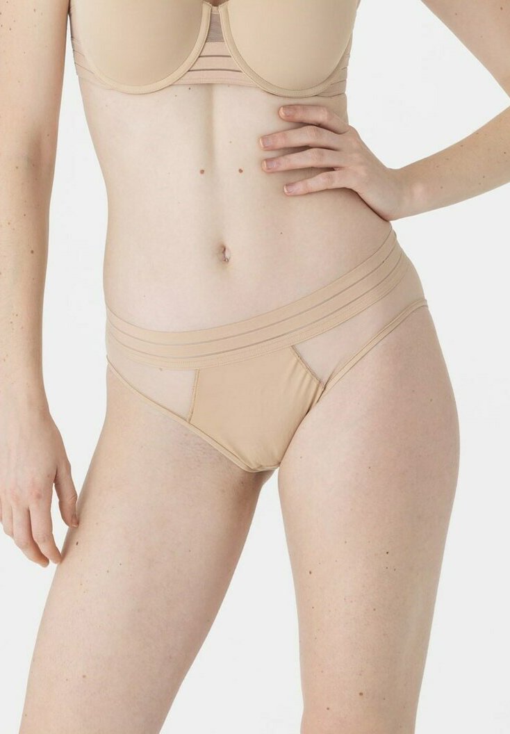 Bas de bikini nude avec une texture lisse, doté de fines bandes élastiques à la taille et sur les côtés, et d'un panneau avant semi-transparent.