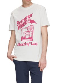 Camiseta de algodón blanca con un diseño gráfico rosa que incluye texto. La ilustración presenta un cóctel, cubos de hielo, un flamenco y una rodaja de limón.