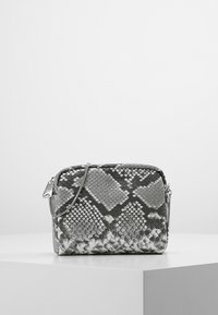 Szara torebka crossbody z wężowej skóry z zapięciem na zamek, srebrnymi akcentami i regulowanym paskiem. Teksturowana powierzchnia z wzorem łusek.