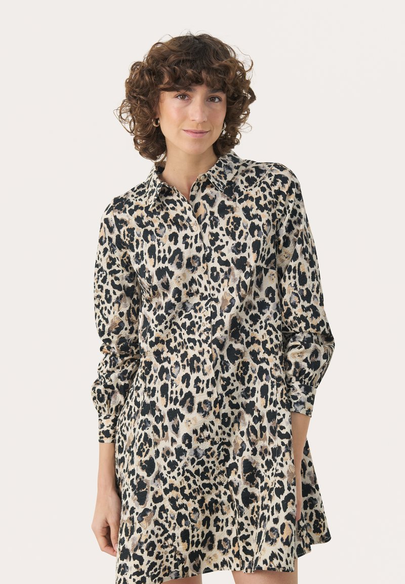 Abito a stampa leopardata, con collo a camicia, maniche lunghe e orlo svasato. Realizzato in tessuto leggero con una texture morbida.