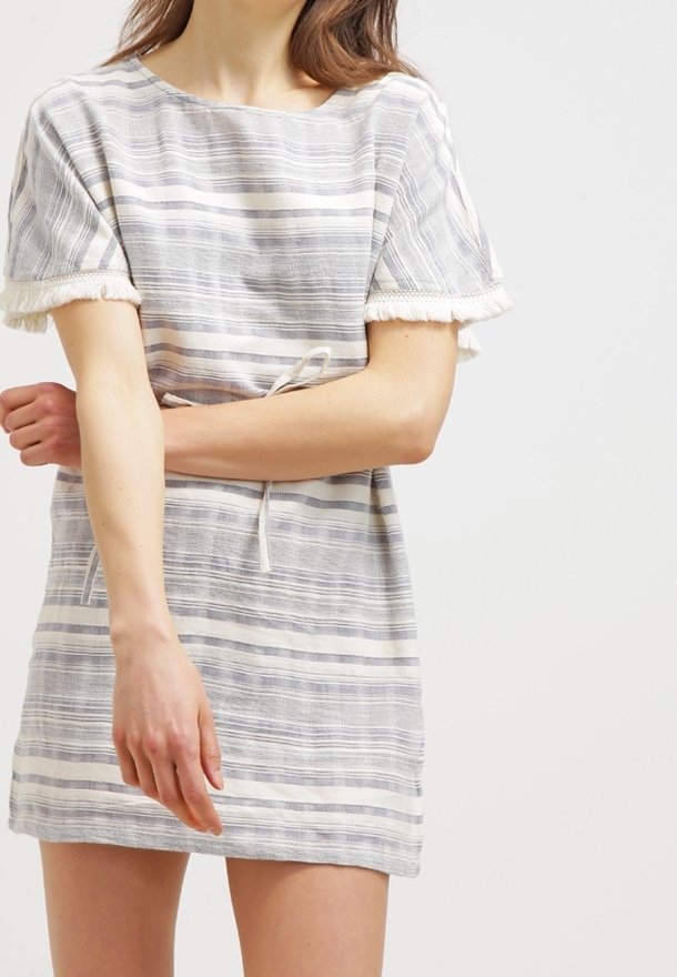 Raidallinen vaaleanvärinen mekko, jossa on lyhyet hihat, teksturoitu kangas, naru vyötäröllä ja frangeja hihoissa.