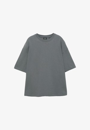 Prosty, ciemnoszary, oversize T-shirt z krótkim rękawem, okrągłym dekoltem i widoczną metką marki w środku kołnierza, na białym tle.