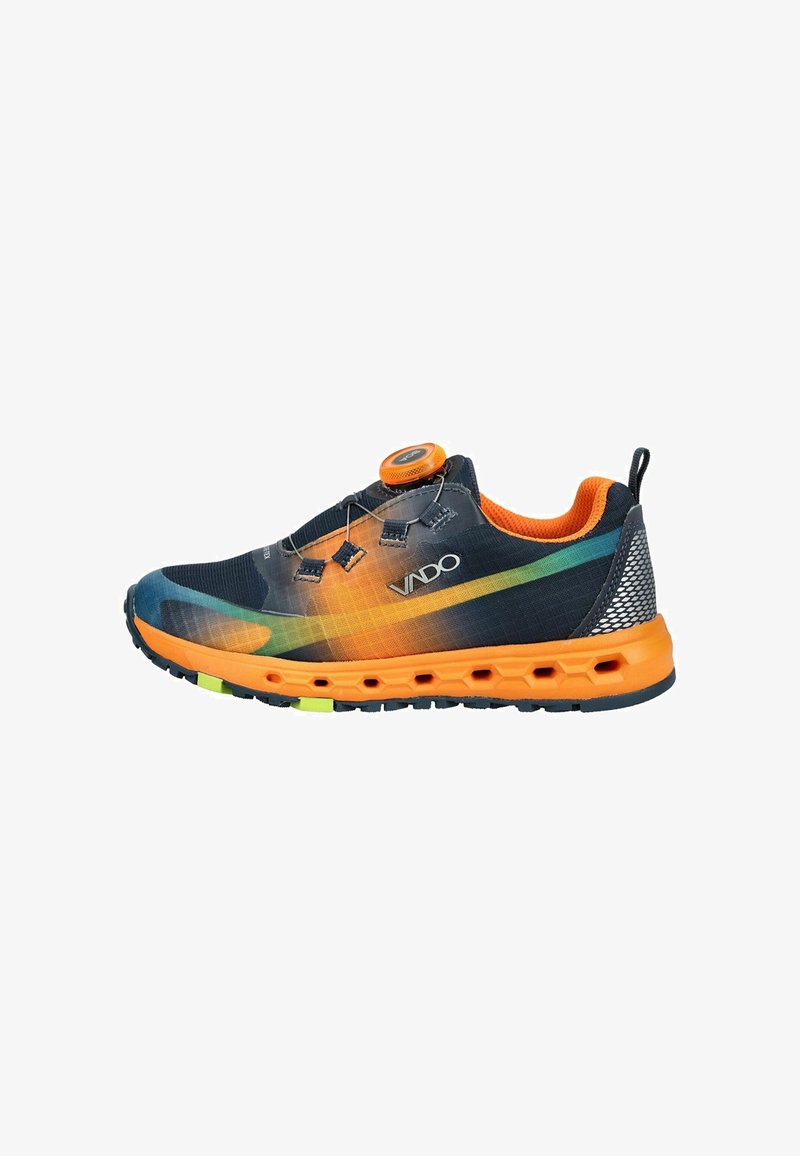 Zapatilla deportiva con suela y forro naranja, parte superior negra con degradado en verde y amarillo, con cierre de cordones giratorio y el nombre de la marca "VADO" en el lateral.