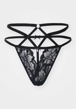 String in pizzo nero con motivo floreale, dotato di fettuccine incrociate sul retro, accentato da un fiocco in satin e realizzato in tessuto morbido e strutturato.