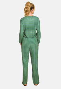 Groen gestreepte lange mouwen top en bijpassende wijde broek, met verticale strepen in verschillende breedtes en een ontspannen pasvorm.
