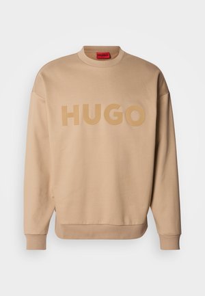 Bežinis megztinis su apvalia kaklo iškirpte, įrengtomis rankovėmis ir apatine juosta. Priekyje yra didelis, matinės spalvos, toninis "HUGO" logotipas.