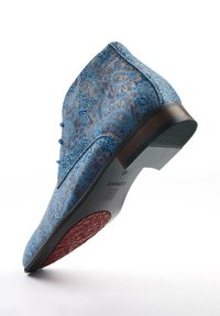 Blue paisley patterned boot with lace-up design, smooth texture, and a brown heel. Notable red rubber sole with grip details.