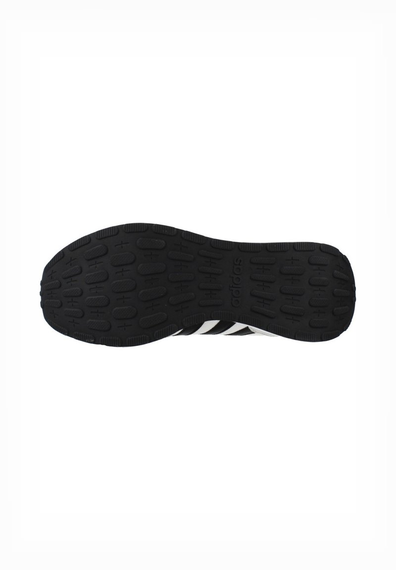 Black rubber outsole with textured grip and white diagonal stripes; features raised circular and lined pattern for traction.