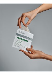 Doctor Babor hemp fiber sheet mask in a white packaging with green accents; textured surface with labels indicating its mattifying and balancing properties.