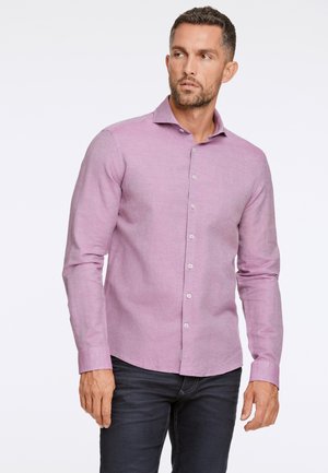 Lichtroze langemouwen shirt van geweven stof met een button-down kraag, voorzien van witte knopen en een slim fit. Een paar donkere spijkerbroeken zijn zichtbaar.