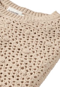 Beige gestrickter Pullover mit einem offenen Webmuster, rundem Ausschnitt und einem gerippten Kragen. Strukturiertes Garn sorgt für visuelles Interesse.