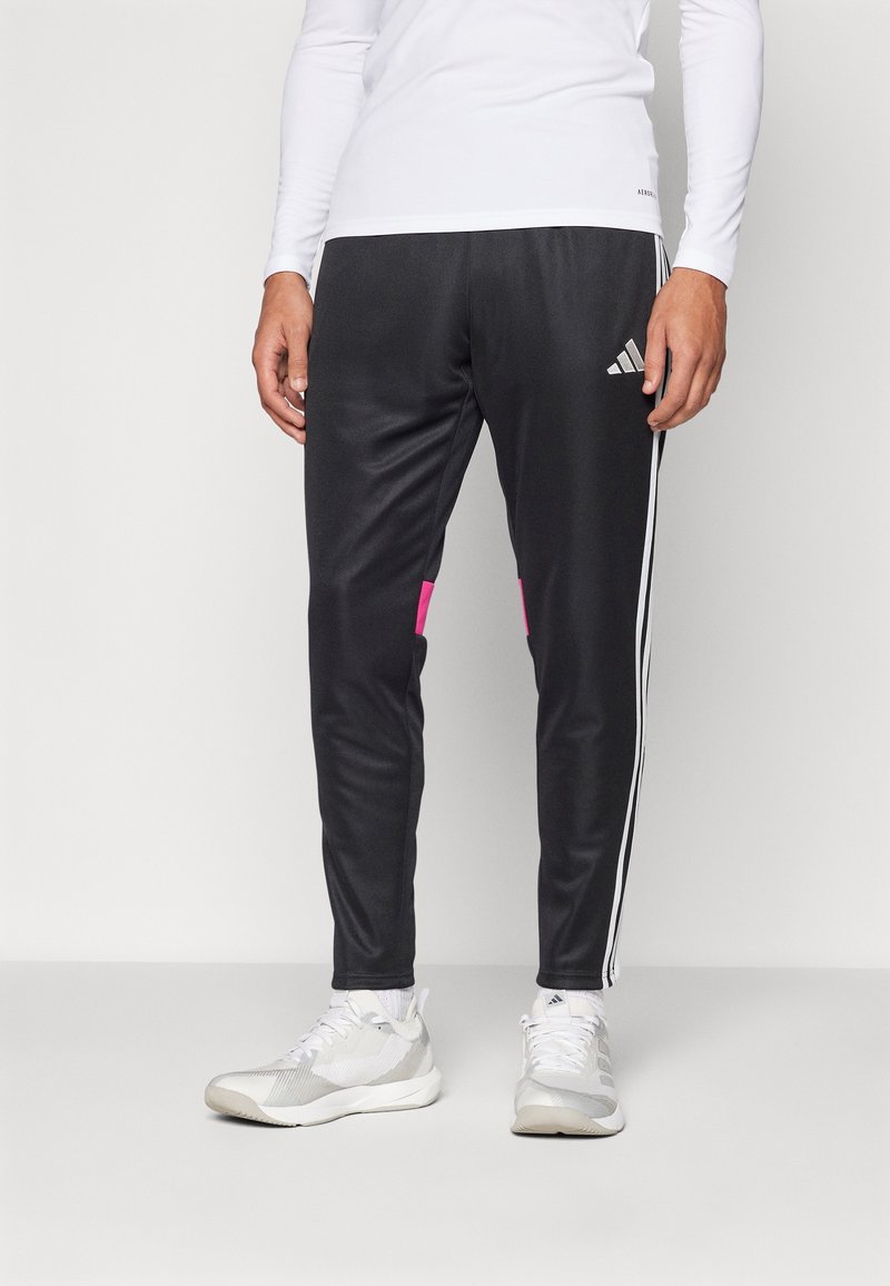 Zwarte sportbroek met roze accenten, gemaakt van een gladde stof. Beschikt over witte strepen langs de zijkanten en heeft een aansluitend ontwerp.