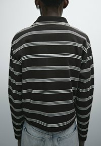 Brown and white striped long-sleeve polo shirt with a collar, featuring a cropped design and textured fabric. Back view shown.