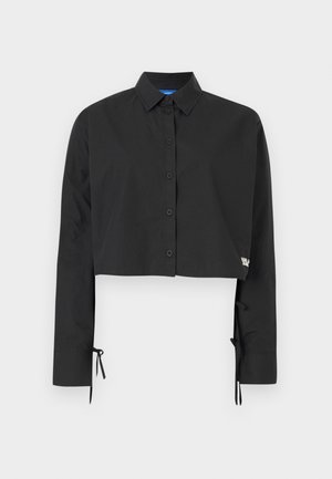 Camisa cropped preta com design de botão, mangas longas, detalhes de laço ajustáveis nos punhos e um discreto detalhe de marca.