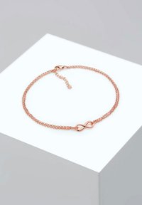 Armband i roséguld med kedjedesign som har en central oändlighetssymbol. Slät yta och en krabba-lås med en förlängningskedja.
