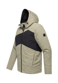 Khaki- och svart huva jacka med diagonalt färgblockdesign, fram dragkedja och sidofickor. Materialet verkar texturerat och isolerat.