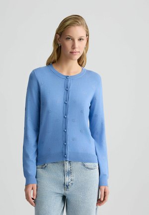 Light blue cardigan with long sleeves, round neckline, button closure, embroidered pattern, and ribbed cuffs. Paired with light denim jeans.