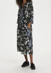 Robe midi fleurie en tissu noir, ornée d'un mélange de fleurs bleues et blanches, avec un décolleté en V, des manches trois-quarts et des poches latérales.