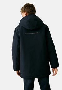 Marineblaue wasserdichte Jacke mit Kapuze, ausgestattet mit einem reflektierenden Streifen auf dem Rücken, langen Ärmeln und geradem Schnitt.