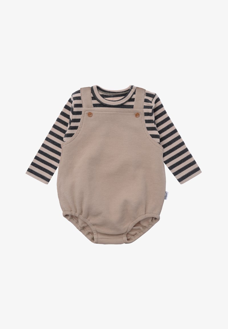 Beiger strukturierter Jumpsuit mit Knopfakzenten über einem schwarz-weißen gestreiften Langarmshirt, mit elastischen Beinöffnungen.