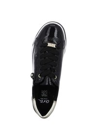 Baskets en cuir verni noir avec surface texturée, accent doré sur la languette, lacets élastiques et semelle blanche contrastante.