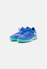 Scarpe sportive blu con parte superiore in rete testurizzata, dotate di lacci blu scuri, suola verde menta e dettagli bianchi sui lati.