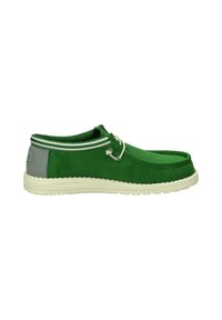 Scarpa in tela verde con suola in gomma bianca, caratterizzata da punta tonda, tallone grigio a contrasto e dettagli a strisce nel colletto.