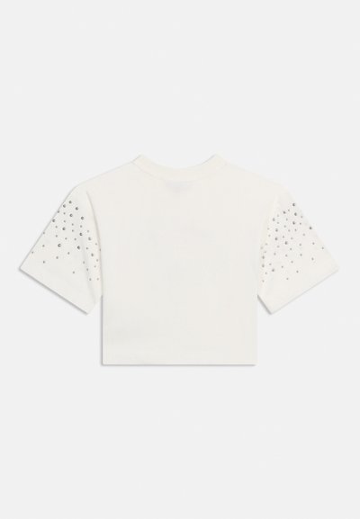 Λευκό κοντό τοπ με κοντά μανίκια και στρογγυλή λαιμόκοψη, διακοσμημένο με μικρές ασημένιες τρουκς διάσπαρτες και στα δύο μανίκια.