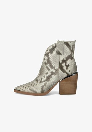 Botte pour femme montant à la cheville, avec bout pointu, dessus en imprimé serpent texturé, languette de tirage latérale et talon épais en bois empilé.