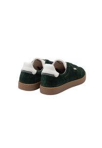 Baskets en suede vert avec des accents blancs et une semelle en caoutchouc brun texturé. Avec un laçage à l'avant et un col rembourré.