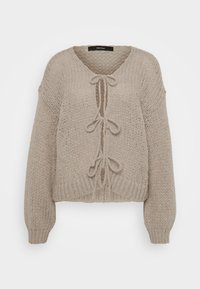 Beige neulejakku, jossa on V-kaula-aukko, etuosan nauhat, pitkät hihat ja ribbireunat. Pehmeä texture ja mukava muotoilu.