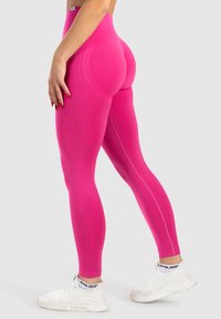 Sopivat vaaleanpunaiset leggarit korkealla vyötäröllä, tekstuurilla varustettu kangas ja saumatonta muotoilua. Sivulla logo-tyyli ja kontrastiväriset ompeleet.