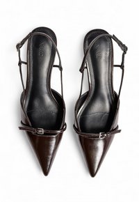 Tacchi slingback in pelle marrone con punta affilata, cinturini alla caviglia e una piccola fibbia decorativa, caratterizzati da una finitura liscia e lucida.