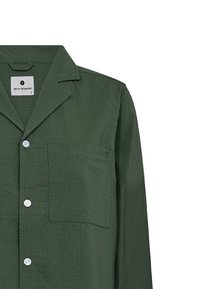 Grøn, tekstureret skjorte med notched krave, lomme foran og hvide knapper. Har brandskilt indeni kraven. Sandsynligvis en blanding af bomuld eller linned.