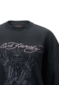 Czarna bluza z okrągłym dekoltem, z szarym haftowanym napisem i grafiką, w tym skrzydłami oraz napisem "NOWY JORK."