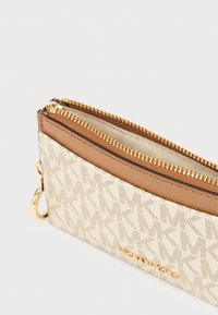 Καφέ και κρεμ πορτοφόλι με φερμουάρ, με υφή εξωτερικής επιφάνειας με μοτίβο λογότυπου, χρυσά μεταλλικά στοιχεία και επένδυση από ταμπά δέρμα.