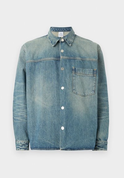 Τζιν μπουφάν με ξεβαμμένο πλύσιμο, κουμπιά με πατιλέτα μπροστά, μυτερό γιακά, μακριά μανίκια και μία τσέπη στο στήθος σε λευκό φόντο.