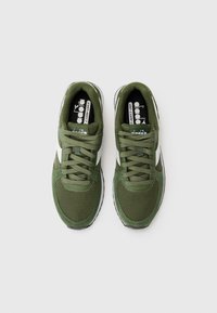Green mesh and fabric sneakers with white accents, rounded toe, textured upper, and flat laces. Rubber sole with slight tread pattern.
