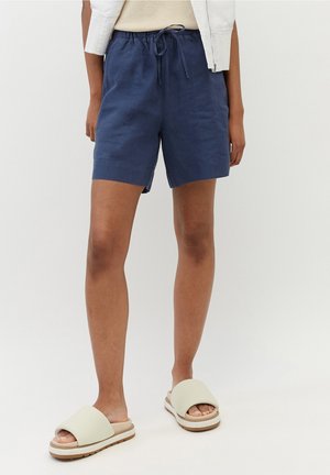 Shorts in lino blu navy con vita elastica e coulisse. Presentano una vestibilità rilassata, un taglio fino al ginocchio e tasche laterali.