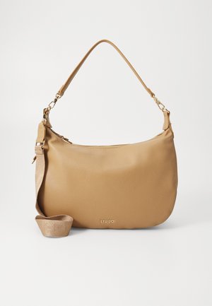 Beige leren schoudertas met één korte handgreep, een afneembare langere band en een klein metalen logo aan de voorkant in het midden.