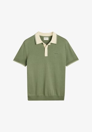 Polo a maniche corte in cotone verde oliva, con colletto crema a contrasto, pattina con tre bottoni e ricamo del logo sottile.