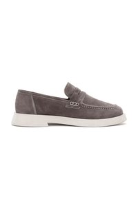 Mocasines de ante en gris con un diseño sin cordones, acentos cosidos y una suela de goma blanca. Presenta un detalle perforado en la parte superior.