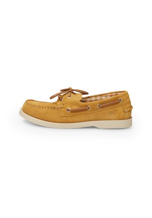 Scarpa da barca in suede gialla con suola in gomma bianca, lacci e occhielli in metallo. Motivo a scacchi visibile sulla fodera interna.