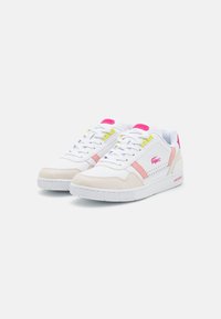 White sneakers with pink and yellow accents. Made of leather and textile, featuring a textured toe cap and a rubber sole. Minimalist design.