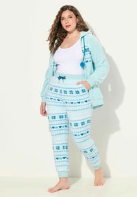 Světlomodrá mikina z fleecu s vzorem sněhových vloček a detailem v podobě bambulí, v kombinaci s odpovídajícími vzorovanými tepláky s elastickým pasem a stahovací šňůrkou.